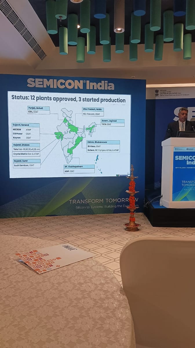 India Semiconductor Mission status slide at SEMICON India 2026: 12 chip plants approved and 3 in production across Punjab, Uttar Pradesh, Assam-Jagiroad, Gujarat, Odisha and Andhra Pradesh, with Tata, Micron, HCL-Foxconn, CG Power and Kaynes flagged